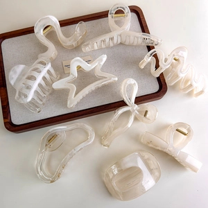 Close-up of assorted pearl white geometric hair claws with smooth matte finish