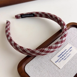 Detail of red and white plaid headband with handmade label on inner lining