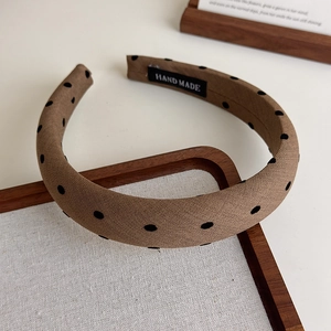 Détail du serre-tête en tissu café avec pois noirs et étiquette faite à la main