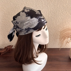 Detail showing the metallic silver tie-dye texture and retro fabric of the headscarf