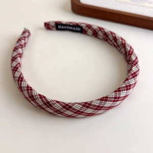 Close-up of red and white plaid headband with a handmade woven label inside