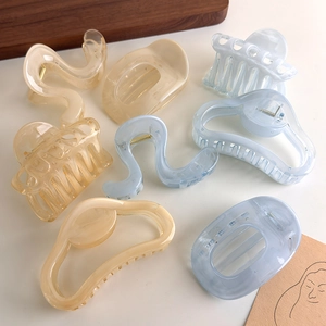 Detail of translucent cloud geometric hair claws in soft orange and blue tones