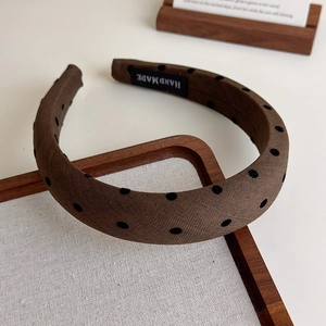 Détail d'un serre-tête fait main en tissu marron à pois avec texture éponge