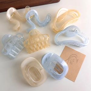 Minimalist translucent geometric claw clips in cloud white, blue, and amber resin colors