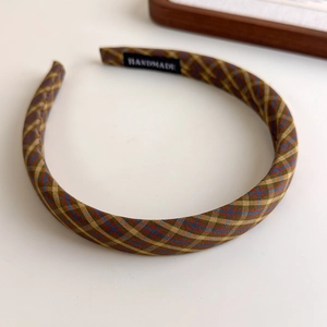 Detail of the handmade woven label and vintage plaid fabric texture on a slim headband