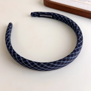 Detailed macro view of the handmade woven label inside the blue plaid headband