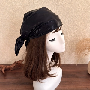 Detail showing the shiny black satin headscarf tied on a brunette model for Y2K style