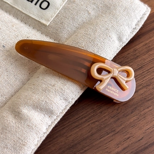 Detailed close-up of acetate bow hair clip with gold France Handmade lettering