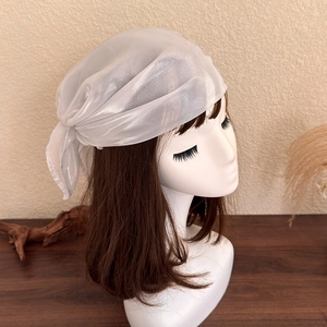 Detailed macro view of white translucent headscarf texture with subtle pearlescent silk sheen