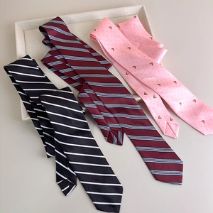 Detailed close-up of striped silk ties and a pink bee embroidered necktie set