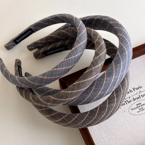 Detail showing high-quality textured linen fabric and handmade label on headbands
