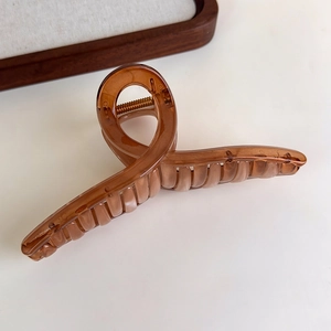 Detailed view of the amber brown translucent hair claw clip with strong metal spring