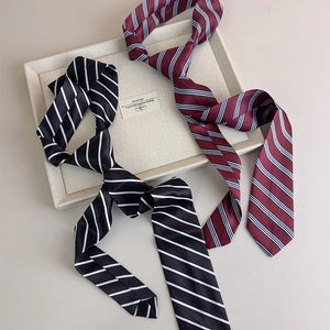 Detail view of preppy style striped ties in black and burgundy with smooth satin texture