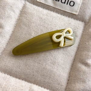 Macro detail of olive green acetate hair clip with bow and France Handmade engraving