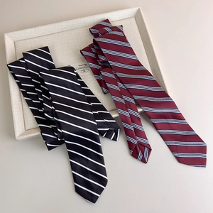 Detailed close-up of striped silk neckties in classic black and burgundy satin fabric