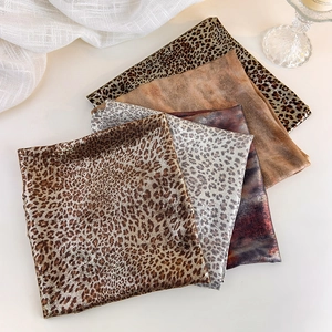 Close-up of assorted leopard print and tie-dye silk scarves for Y2K vintage hair styling