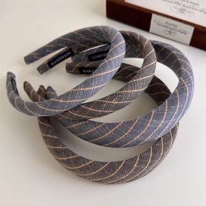 Detailed view of handmade pinstripe headbands featuring quality fabric and woven labels