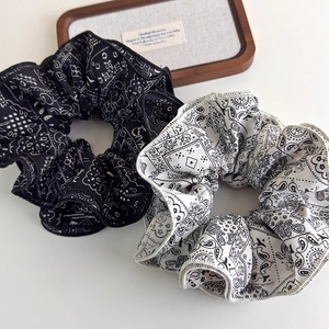 Elegant set of black and white paisley print fabric scrunchies with a vintage aesthetic