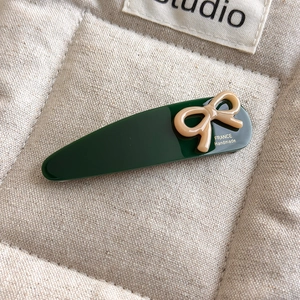 Detailed close-up of a green acetate hair clip with a chic bow and France handmade text