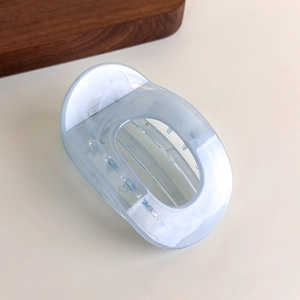 Macro shot of light blue translucent marble hair claw clip with geometric cutout design