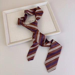 Detailed macro view of the dark brown striped tie featuring a silky texture and silk fabric