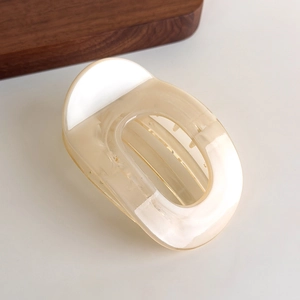 Detailed view of cream beige acetate hair claw with elegant marble texture and gold spring