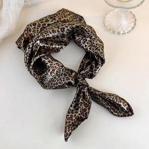 Close-up of a leopard print silk headscarf with metallic luster and soft texture