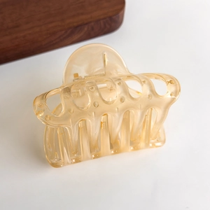 Detailed macro shot of translucent amber hair claw clip with strong metal spring