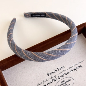 Detail view of handmade pinstripe headband with woven texture and premium finish