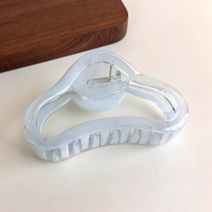 Detail of light blue cloud-pattern hair claw clip with strong spring and translucent finish