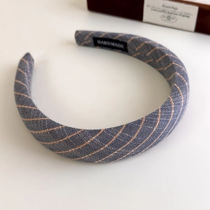 Detailed view of handmade vintage navy linen headband with orange stripes and woven label