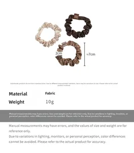 Close-up of three satin scrunchies in beige and brown tones with soft pleated fabric texture