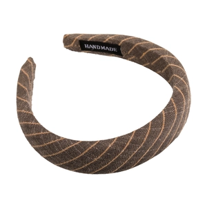 Detail of brown fabric headband with yellow diagonal stripes and handmade woven label