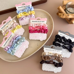 Three-piece set of satin scrunchies in vibrant macaron colors on a display card
