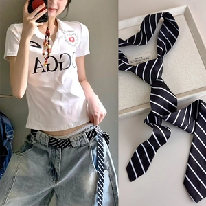 Cravatta sottile a righe bianche e nere usata come cintura alla moda minimalista