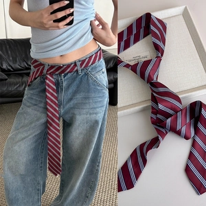 Elegante cravatta a righe rosso vino indossata come cintura decorativa per uno stile chic