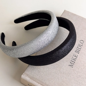 Detail showing two padded headbands in silver glitter and black sponge texture set