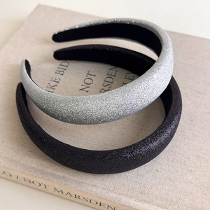 Vintage glitter padded headbands in silver and black on a book for a retro aesthetic look