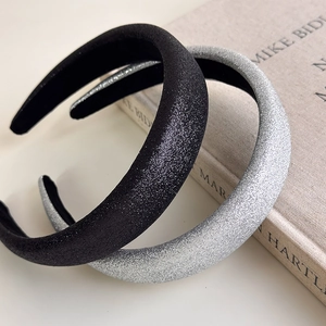 Close-up of glitter sponge headbands in black and silver on vintage book props