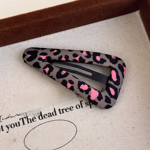Detailed macro view of fabric-wrapped leopard print hair clip in a premium display box