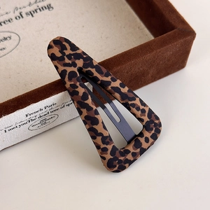 Close-up of leopard print hair clip showing textured fabric and black metal snap detail