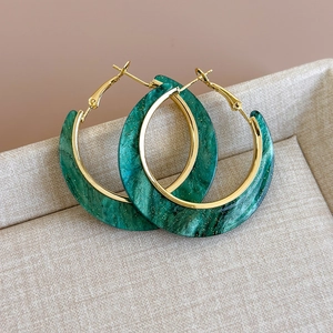 Macro detail of emerald marble resin hoop earrings with gold foil and C-shape frame