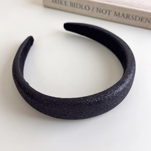 Close-up of glitter sponge headband showing sparkling texture and wide curved frame