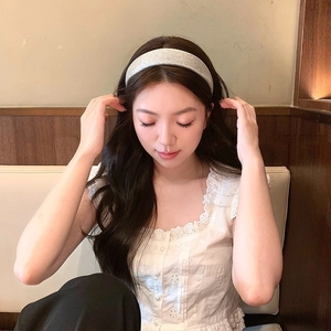 Chic silver glitter padded headband for high cranial top hairstyle on model in cafe