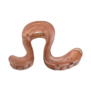 Macro detail of brown translucent resin hair claw clip with golden metal spring