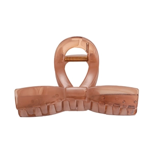 Detail of translucent amber resin hair claw clip with bow design and metal spring mechanism