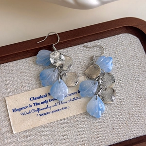 Detail of blue petal drop earrings with silver textured metal discs and frosted finish