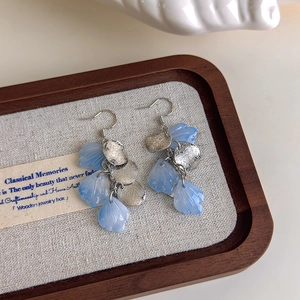 Elegant gradient blue petal earrings with silver matte metal on linen tray