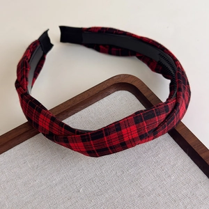 Détail d'un serre-tête en tissu écossais rouge et noir avec dents antidérapantes pour le style