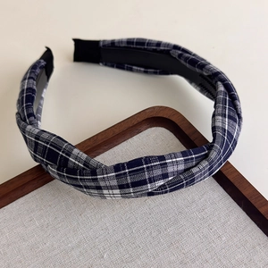 Détail du bandeau torsadé à carreaux bleu marine et blanc sur un plateau en bois